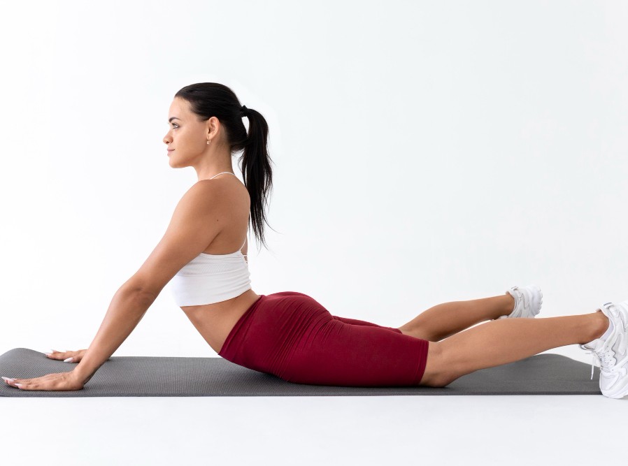 Frau macht eine Yoga-Cobra-Position auf einer Matte – Übung für Rücken, Beweglichkeit und Entspannung.
